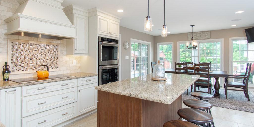 Kitchen with white cabinets and center island in an amiano and son home remodel
