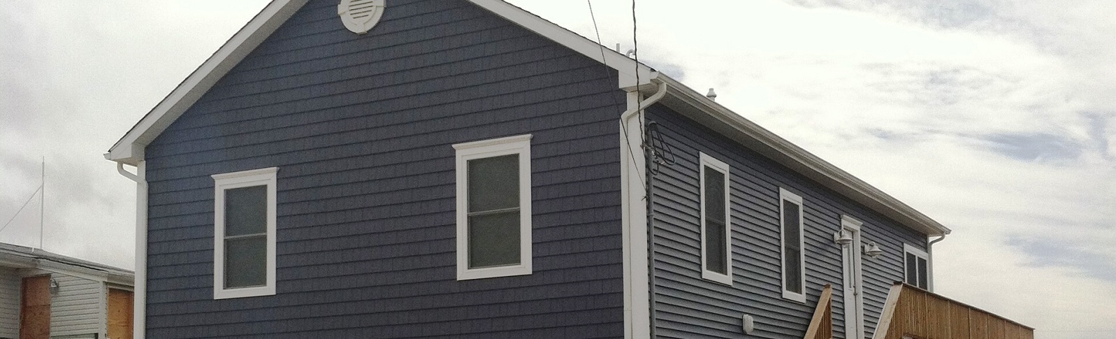 After renovation photo of a blue home from amiano and son