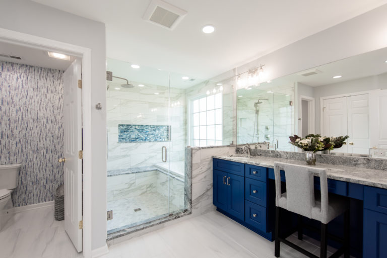 Renovated bathroom with blue cabinets and large shower from Amiano and son